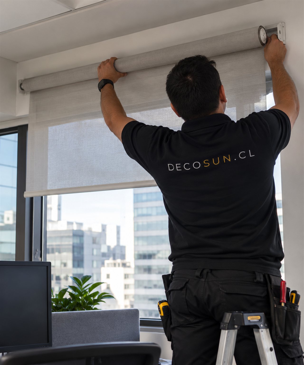 Técnico DecoSun desmontando manualmente una cortina Roller Screen en una oficina